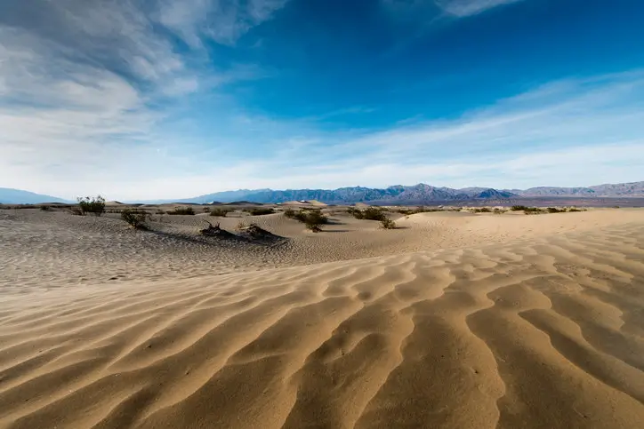 A dramatic desert landscape with sand dunes.