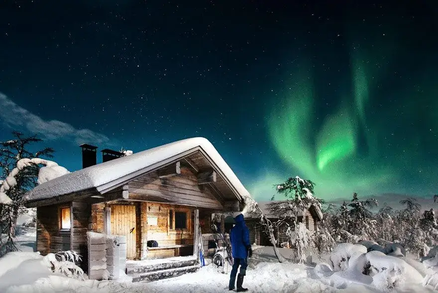 Snowy alpine village under the northern lights.