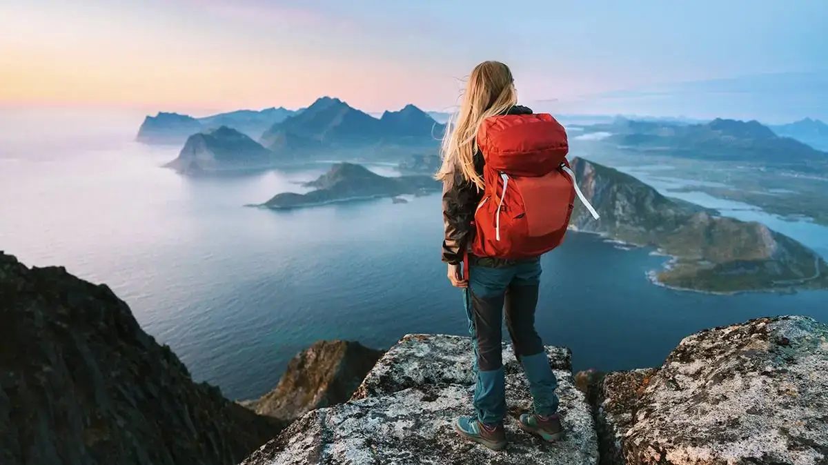 A hiker looking out over a vast mountain valley, representing exploration.