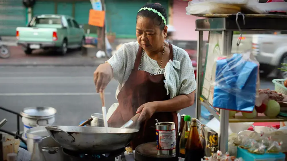 A person enjoying street food from a vendor in Thailand.