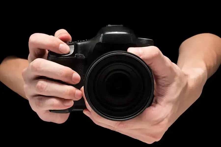 Close-up of a person's hands holding a camera.